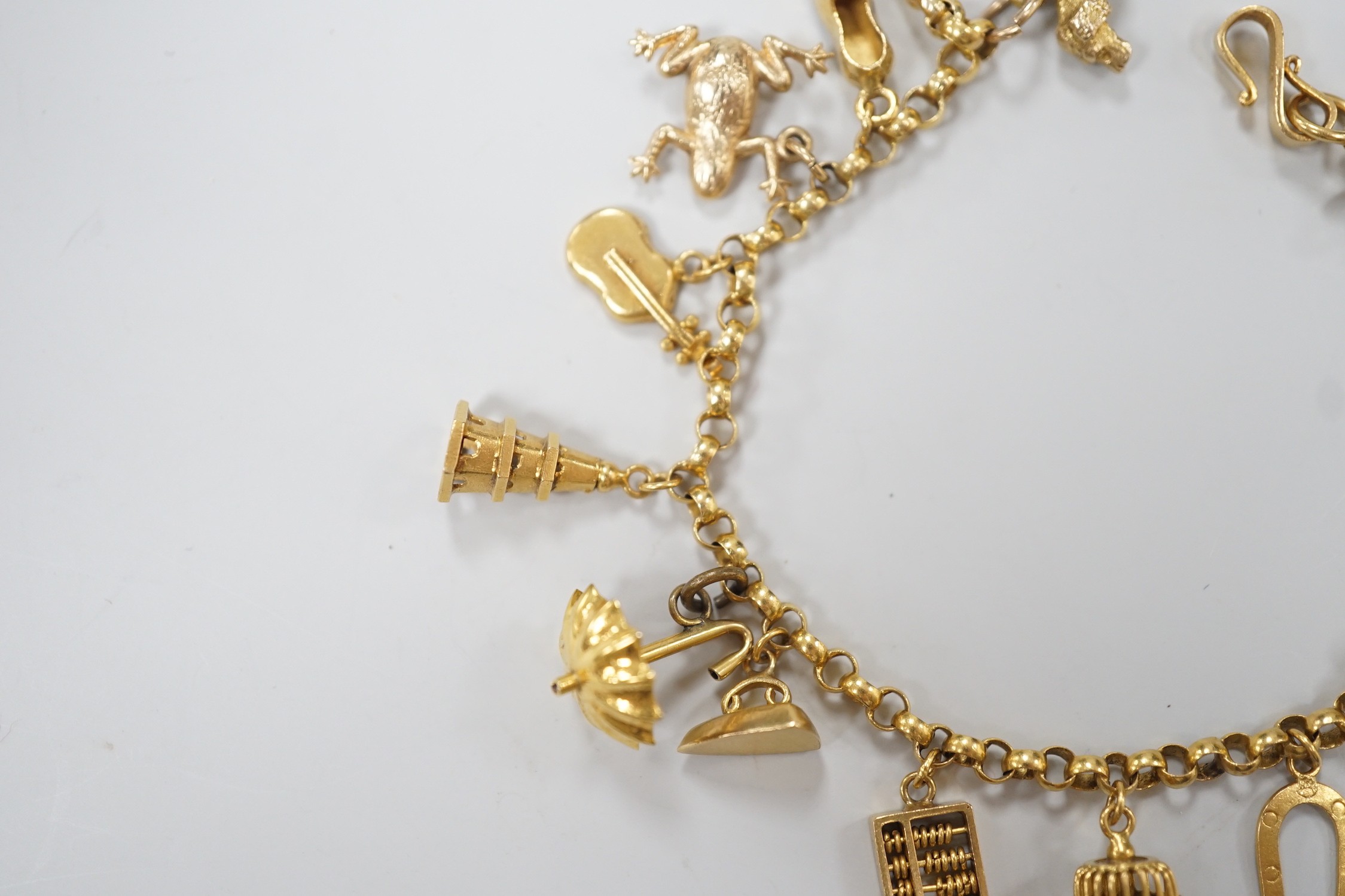 A Chinese yellow metal charm bracelet, hung with thirteen assorted yellow metal charms including four 9ct, 15.5cm